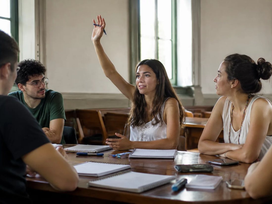 Dupla preparando a rodada seguinte com cadernos e marcadores espalhados na mesa